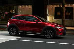 A CX 3 parked by the side of the road.